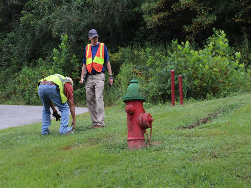 Men inspecting around hydrant